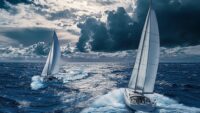 midyear planning for hvacr distributors is like two sailboats cutting through choppy blue water under a dramatic, cloud-filled sky, leaving zigzag wakes behind them — symbolizing adaptability and steady navigation through changing conditions.