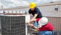 HVAC technician working on commercial rooftop unit representing the growing technician shortage